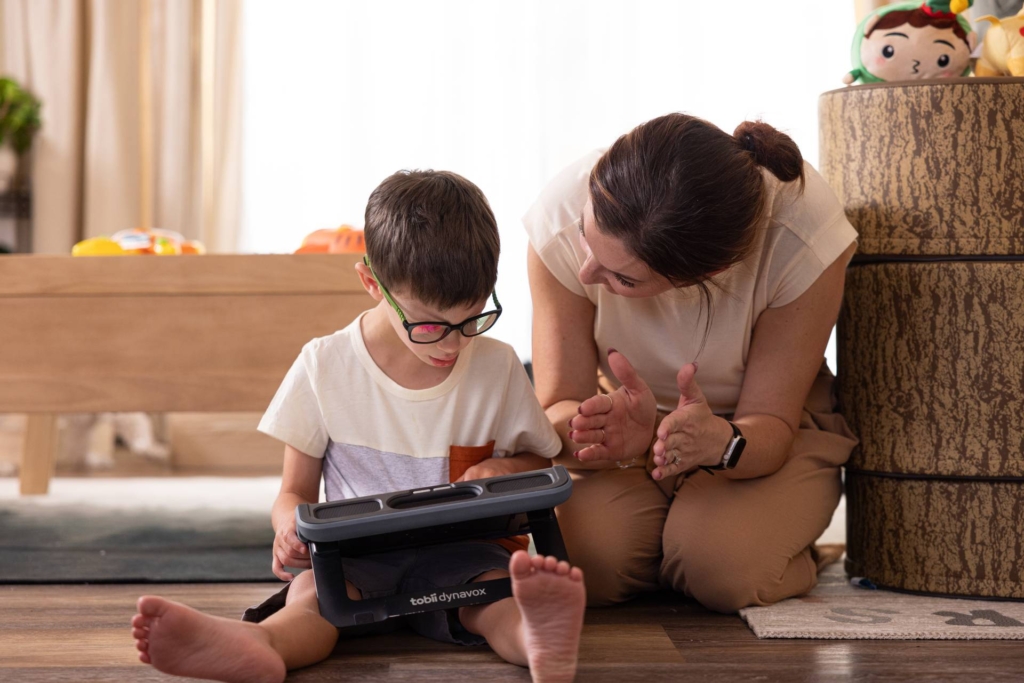 Autistic boy communicating with his mother using a TD Navio speech device by Tobii Dynavox.